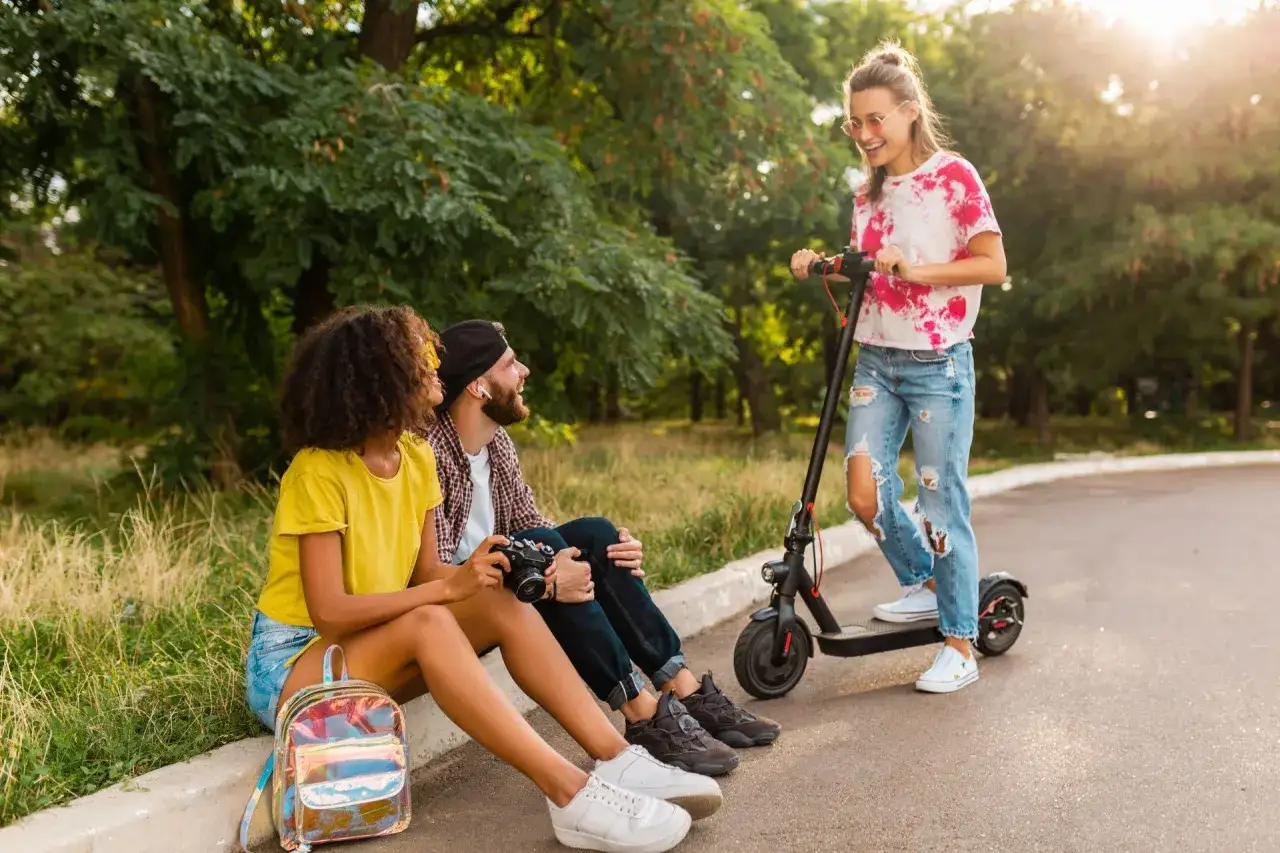 Młoda osoba na hulajnodze elektrycznej w ruchu miejskim