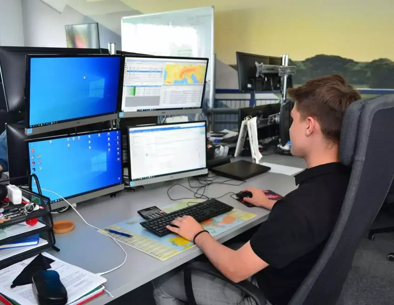 Spedytor przy komputerze z mapami i telefonem